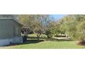 Side yard of the mobile home with grass and trees at 6434 Garvey Dr, New Port Richey, FL 34652
