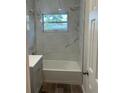 Updated bathroom with a bathtub, gray vanity, and marble-look tile at 7142 Carlow St, New Port Richey, FL 34653