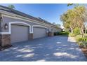 Three-car garage with paver driveway at 9728 Milano Dr, Trinity, FL 34655