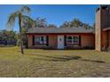 Brick house with a white door and windows, nicely landscaped at 10525 Hilltop Dr, New Port Richey, FL 34654