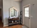 Bright entryway with console table, mirror, coat rack and door with window panels at 1249 Mazarion Pl, Trinity, FL 34655