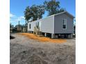 Gray manufactured home on a lot with new landscaping at 1925 Patriot Ln, Holiday, FL 34690