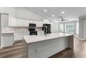 Modern kitchen with white cabinets, black appliances, and a large island at 2468 Magellan Ave, Spring Hill, FL 34608