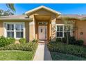 Front entrance with white door and well-manicured landscaping at 6604 Rosemont Ct, New Port Richey, FL 34655