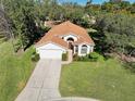 Bird's eye view of a single-story house with a brown roof and a driveway at 11445 Deercroft Ct, Spring Hill, FL 34609