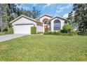 Single-story home with a two-car garage and well-manicured lawn at 11445 Deercroft Ct, Spring Hill, FL 34609