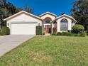 Single-story house with a two-car garage and well-maintained lawn at 11445 Deercroft Ct, Spring Hill, FL 34609