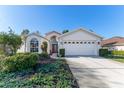 Front view of a single-story house with a two-car garage and nicely landscaped yard at 11544 Mcleod St, Spring Hill, FL 34609