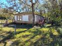Mobile home with a fenced yard, situated on a spacious lot with mature trees at 12924 Manatee Ave, New Port Richey, FL 34654