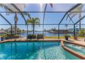 Inviting pool and spa with screened enclosure and water view at 3298 Gulfview Dr, Hernando Beach, FL 34607