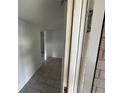 View of the hallway with tile flooring, white walls, and an open doorway from the main entrance at 7552 Cumber Dr, New Port Richey, FL 34653
