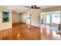 Bright, open living area featuring wood floors, a ceiling fan, and views into the kitchen at 7662 St Andrews Blvd, Weeki Wachee, FL 34613