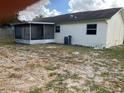 Back of the house with a screened porch and a large backyard at 8525 Gandy Ln, Port Richey, FL 34668