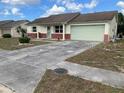 Front view of a ranch style home with a driveway and landscaping at 8525 Gandy Ln, Port Richey, FL 34668