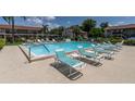 Community pool with multiple lounge chairs for relaxing at 9980 Eagles Point Cir # 3, Port Richey, FL 34668