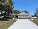 Charming single-story home featuring a white exterior, stone accents and a wide driveway at 1000 Godfrey Ave, Spring Hill, FL 34609