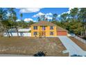 Two-story house with orange accents, a white fence, and a driveway at 10191 Jordan St, Spring Hill, FL 34608