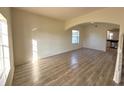 Open living room with new laminate wood-look flooring, arched entryway and natural light at 12336 Southbridge Ter, Hudson, FL 34669