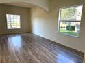 Bright living room with new laminate floors, large windows offering ample natural light and neutral tones at 12336 Southbridge Ter, Hudson, FL 34669