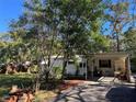 Mobile home with carport and mature trees at 12520 Hicks Rd, Hudson, FL 34669