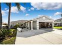 Single-story home with a two-car garage, palm trees, and a driveway at 13610 Evelane Dr, Hudson, FL 34667