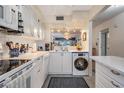 White kitchen with stainless steel appliances and marble countertops, laundry in kitchen at 3660 Trophy Blvd, New Port Richey, FL 34655