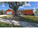 Single-story home with attached garage and mature tree at 465 Meadowlark Ln, Palm Harbor, FL 34683