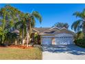 Spacious house with a three-car garage and mature landscaping at 5211 Karlsburg Pl, Palm Harbor, FL 34685