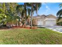 House with a large yard, three-car garage, and palm trees at 5211 Karlsburg Pl, Palm Harbor, FL 34685