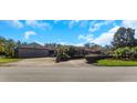 House exterior with a large garage and landscaping at 8700 Cessna Dr, New Port Richey, FL 34654