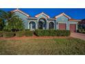 Stunning curb appeal of this teal home with red tile roof and manicured lawn at 10645 Ruffino Ct, Trinity, FL 34655