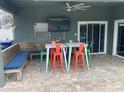 Covered patio with seating, a large TV, and built-in bench at 1922 Oswego Dr, Holiday, FL 34691