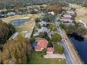 Bird's-eye view of a community with houses near a golf course and pond at 3042 Wentworth Way, Tarpon Springs, FL 34688