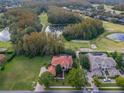 House with red tile roof and pool, located in a lush golf course community at 3042 Wentworth Way, Tarpon Springs, FL 34688