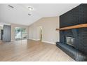 Spacious living room with a brick fireplace and light wood floors at 3127 57Th Avenue E Cir, Bradenton, FL 34203