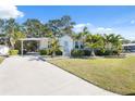 Attractive home exterior with a well-maintained lawn and palm trees at 4620 Tri Par Dr, Sarasota, FL 34234