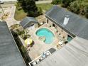 Aerial view of backyard featuring a kidney shaped pool, spa, patio, and well-maintained home at 7941 Sycamore Dr, New Port Richey, FL 34654