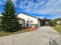 Front view of a house with a carport and manicured landscaping at 9163 Lingrove Rd, Weeki Wachee, FL 34613