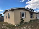 Side view of tan single-story house with white shutters at 1005 Embassy Ave, Spring Hill, FL 34606