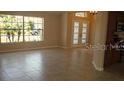 Bright living room features tile floors, large windows and front door at 13625 Deventer Ct, Hudson, FL 34667