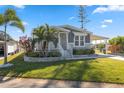 Mobile home with gray siding, landscaping, and a covered carport at 1852 Cypress Point Ln, Sarasota, FL 34234