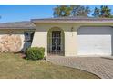 Front view of house with a brick walkway, arched entryway, and decorative gate at 2300 Restmere Ln, Spring Hill, FL 34609