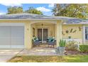 Relaxing covered patio with wicker furniture, creating a welcoming entryway at 6432 Plantation Rd, Spring Hill, FL 34606