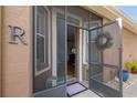 Screened front porch with entry door and festive wreath at 8432 Tarocco Ct, Land O Lakes, FL 34637