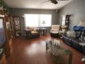 Cozy living room with hardwood floors, two sofas, a large window and multiple display cabinets at 11187 Blythville Rd, Spring Hill, FL 34608