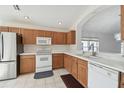 Oak kitchen cabinets, white appliances and tile floor at 11644 Spindrift Loop, Hudson, FL 34667