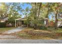 View of the front yard with mature trees, a driveway, and the front of the house at 4939 18Th St, Zephyrhills, FL 33542