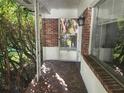 Brick front porch with a storm door and tiled flooring at 7222 N Ola Ave, Tampa, FL 33604
