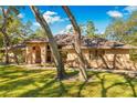 Exterior view of a home with a brown roof, brick accents, and mature trees at 7443 Oak Tree Ln, Spring Hill, FL 34607