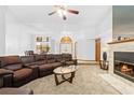 Cozy living room with a fireplace, leather sectional sofa, and ceiling fan at 7443 Oak Tree Ln, Spring Hill, FL 34607